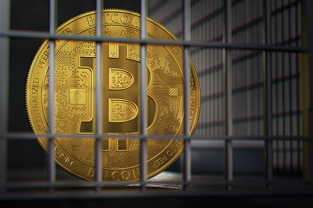 A bitcoin is locked up behind jail bars, implying that it is either being held captive or that it has been used in a crime and is being held in prison.