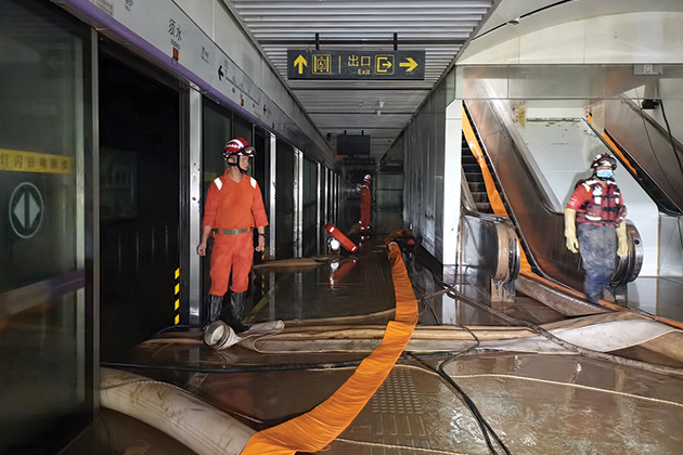 Emergency workers walk through a flooded building in China.