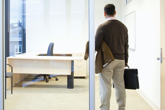 Man with a briefcase returning to an empty office.