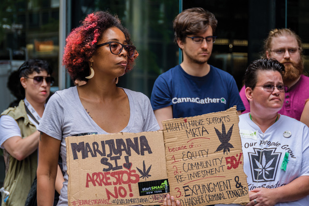 Protesters with signs advocating marijuana legalization.