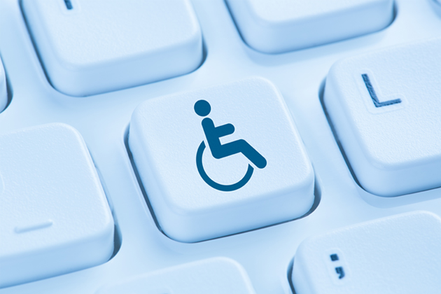 A computer keyboard with the symbol for disability (a person sitting in a wheelchair) on one of the keys.