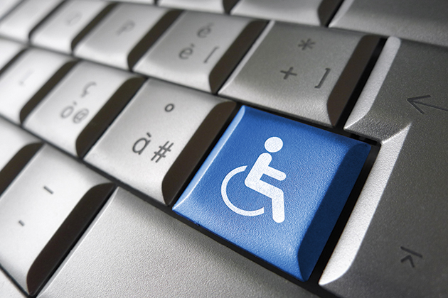 A grey computer keyboard with one key colored blue with the symbol for handicapped on it.