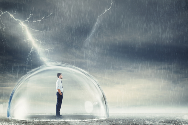 A man in business attire stands on a body of water in the middle of a storm, but he is protected by a bubble. The bubble is also being struck by lightning, but it is not reaching him.