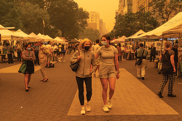 People with masks walking through farmers market during poor air quality alerts