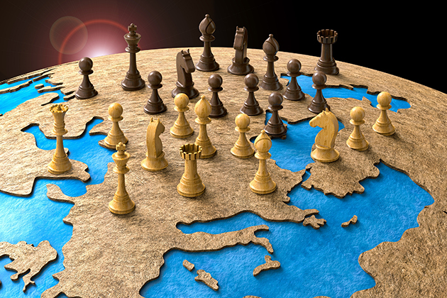 Chess pieces sitting on top of an image of countries on a globe