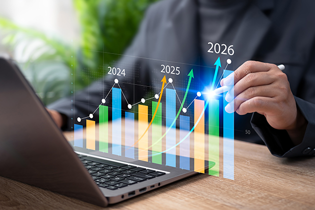 Person in front of a laptop displaying an bar chart showing historical data trends
